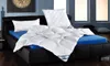 A neatly made bed with a white comforter and pillows on a black bed frame. Anteprima dell’immagine prodotto