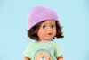 Close-up studio shot of a doll wearing a purple beanie and a green checkered shirt. Produktbild-Vorschau