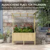 A wooden raised garden bed filled with red flowers and green plants, set against a brick wall. Produktbild-Vorschau