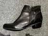 A single black leather ankle boot is shown on a gray carpeted surface. Anteprima dell’immagine prodotto