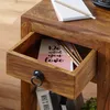 A close-up of an open drawer in a wooden side table, showing a notebook and pencils inside. Náhľad obrázku produktu