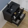 A black bathroom vanity with a sink and open drawers, showing toiletries and toilet paper. Produktbild-Vorschau