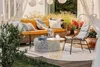 An outdoor patio setting with a sofa, chair, and coffee table. Produktbild-Vorschau
