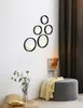 A collection of round mirrors mounted on a white wall, with a grey ottoman and a plant in the foreground. Produktbild-Vorschau