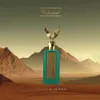 A perfume bottle with a golden eagle topper stands in a desert landscape with mountains in the background. Podgląd zdjęcia produktu