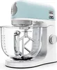 A light blue and white Kenwood KMix stand mixer is shown from a side-angle on a white background. Produktbild-Vorschau
