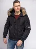 A man wearing a black hooded winter jacket and blue jeans, posing against a white background. Náhled obrázku produktu
