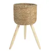 A woven basket planter with a wooden tripod stand, isolated on a white background. Produktbild-Vorschau