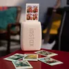 A pink Instax mini Link 3 printer is on a red table, printing photos. Several printed photos are scattered on the table. Anteprima dell’immagine prodotto