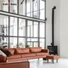 A modern living room with a large window, a brown leather sofa, and a black wood-burning stove. Produktbild-Vorschau