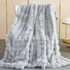 A light gray plush blanket draped over a chair. Náhled obrázku produktu