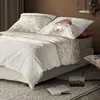 A bed with a duvet cover featuring a sheep illustration and a red hat, set in a bedroom environment. Produktbild-Vorschau