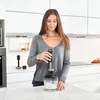 A woman is using a hand blender in a modern kitchen. Podgląd zdjęcia produktu