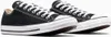 A pair of black Converse All Star low-top sneakers with white laces and soles, shown from a side-angle on a white background. Voir les images du produit