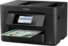 A black Epson WorkForce Pro WF-4820DWF printer is shown from a slightly elevated front-left angle, with a document partially fed into the paper tray. Náhled obrázku produktu