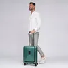 A man is walking with a green suitcase. Podgląd zdjęcia produktu