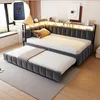 A modern bedroom with a gray upholstered sofa bed, featuring integrated LED lighting and a pull-out trundle bed. Produktbild-Vorschau