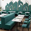 A modern restaurant or cafe interior with teal velvet seating and decorative wall panels. Anteprima dell’immagine prodotto