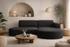A modern living room with a dark grey sectional sofa, a round wooden coffee table, and decorative elements. Produktbild-Vorschau