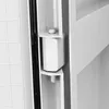 A close-up view of a white plastic hinge mechanism on the inside of a white enclosure, possibly a cabinet or electrical box. Produktbild-Vorschau