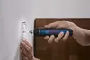 A person is using a Bosch cordless screwdriver to attach a light fixture to a wall. Voir les images du produit