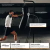 A man is punching a boxing bag that is hanging from a stand. The stand also has a punching ball platform. Produktbild-Vorschau