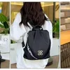 Schwarzer Rucksack mit goldfarbenem Emblem und weißem Text auf dem Gurt, von hinten getragen Produktbild-Vorschau