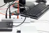 A computer keyboard, USB hub, and external hard drive are connected on a white desk. Voir les images du produit