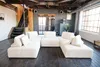 A modern living room with a large sectional sofa, industrial-style stairs, and large windows. Produktbild-Vorschau