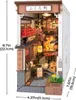 A miniature diorama of a Japanese alleyway with shops and cherry blossoms. Voir les images du produit