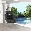 A hanging chair is placed on a wooden deck next to a swimming pool with a view of the ocean. Podgląd zdjęcia produktu