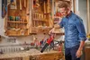 A man is using a leaf blower in a workshop. Produktbild-Vorschau