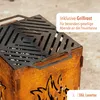 Close-up of a rusty metal fire pit with a grill grate on top, with text overlay. Produktbild-Vorschau