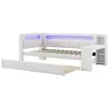 A white daybed with a pull-out trundle bed, featuring integrated LED lighting and a small desk/storage unit. Náhled obrázku produktu