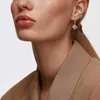 Close-up of a woman wearing a single earring. Anteprima dell’immagine prodotto