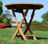 A round wooden folding table in a garden setting. Produktbild-Vorschau