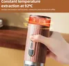 A hand holding a portable coffee maker with heat emanating from the top. Produktbild-Vorschau
