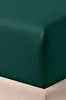 A close-up view of a dark green fitted sheet on a bed. Produktbild-Vorschau