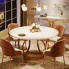 A dining room scene with a round white table and four brown chairs, set for a meal. Podgląd zdjęcia produktu