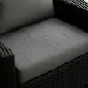 Close-up of a gray cushion on a dark woven chair, with water droplets on the surface. Produktbild-Vorschau