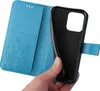 A hand is holding a blue flip phone case with a floral and butterfly embossed design. Produktbild-Vorschau
