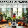 A blender filled with fruit sits on a wooden table in a kitchen setting with plants in the background. Produktbild-Vorschau
