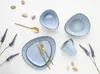 A flat lay of blue ceramic tableware and cutlery with decorative lavender sprigs and stones. Náhľad obrázku produktu