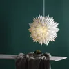 A white paper star lantern hangs against a dark green background, with a small potted plant on a shelf below. Produktbild-Vorschau