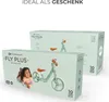 Two boxes of Kinderkraft FLY PLUS balance bikes are shown, one in the foreground and one in the background. A child is lying next to the foreground box. Produktbild-Vorschau