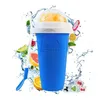 A blue slushy cup with a frozen drink and a straw, surrounded by splashes of water and various fruits like oranges, limes, and grapefruit. Ice cubes with berries are also visible. Podgląd zdjęcia produktu