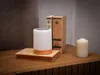 A bedside table setup with a lamp, books, and a candle. Voir les images du produit