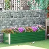 A green metal raised garden bed filled with colorful flowers, placed on a green lawn in front of a stone wall. Produktbild-Vorschau