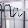 A close-up shot of black metal shower hooks hanging on a glass shower door. Náhled obrázku produktu