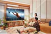 A couple is watching TV in a living room. Produktbild-Vorschau